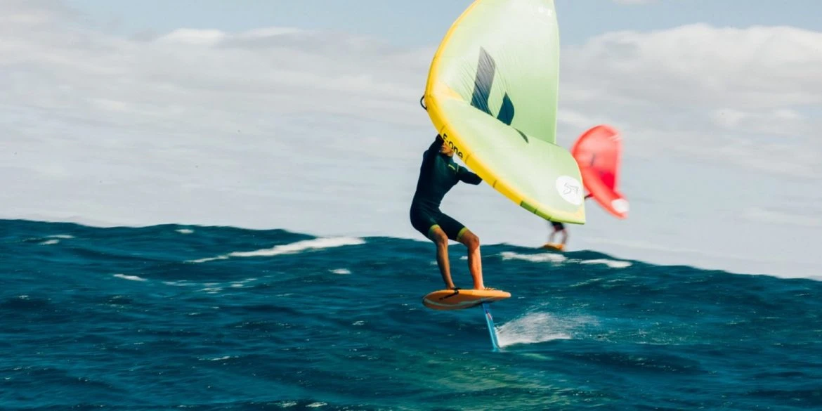 Wingfoil in open water with a yellow and white wing